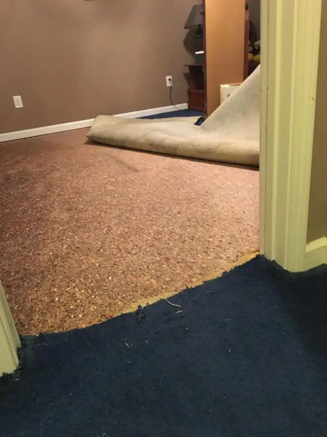 Carpet pad removal revealing water damage during Water Mitigation Services in Weddington
